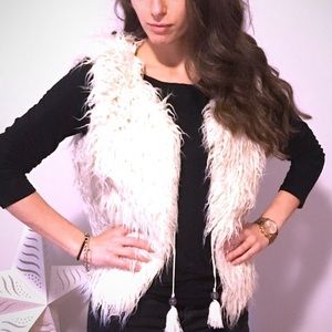 White furry vest with tassels.